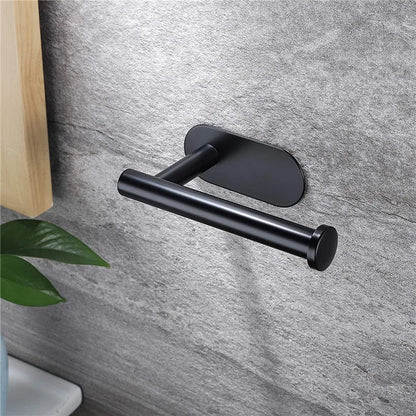 The small matt black roll holder mounted on a grey stone wall beside a wooden cabinet.