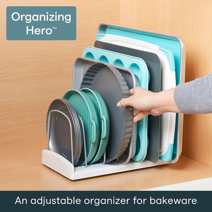 In a cupboard, holding baking trays, a tart tin and a muffin tray