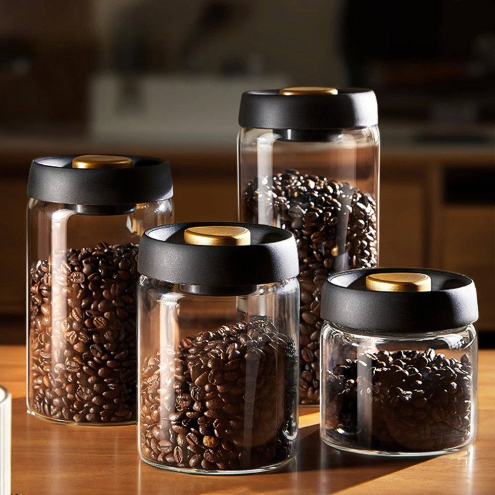 Four sizes of the vacuum coffee canister filled with roasted beans, standing together on a wooden worktop.