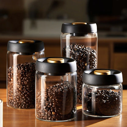 Four sizes of the vacuum coffee canister filled with roasted beans, standing together on a wooden worktop.